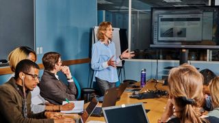 Woman standing and presenting in a team meeting