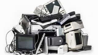 Legacy tech concept image showing a pile of obsolete computers stacked up in a pile.