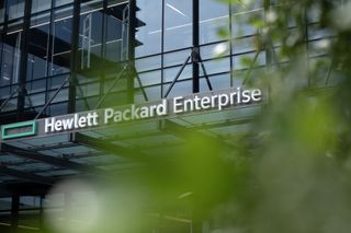 A photo of a Hewlett Packard Enterprise sign above a doorway, partially obscured by green foliage